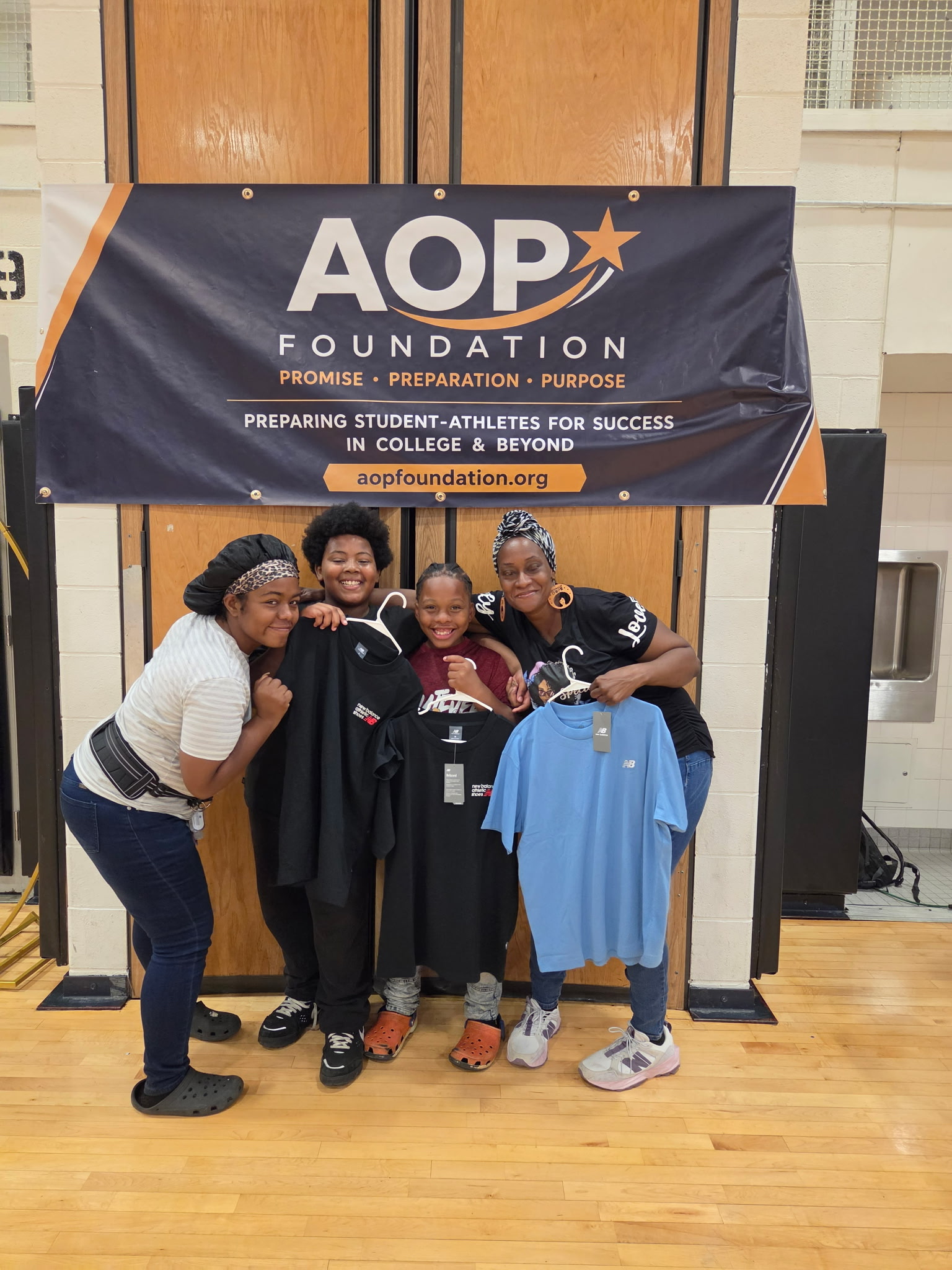 A family holding new clothing and backpacks at the Back-to-School Community Kickoff.