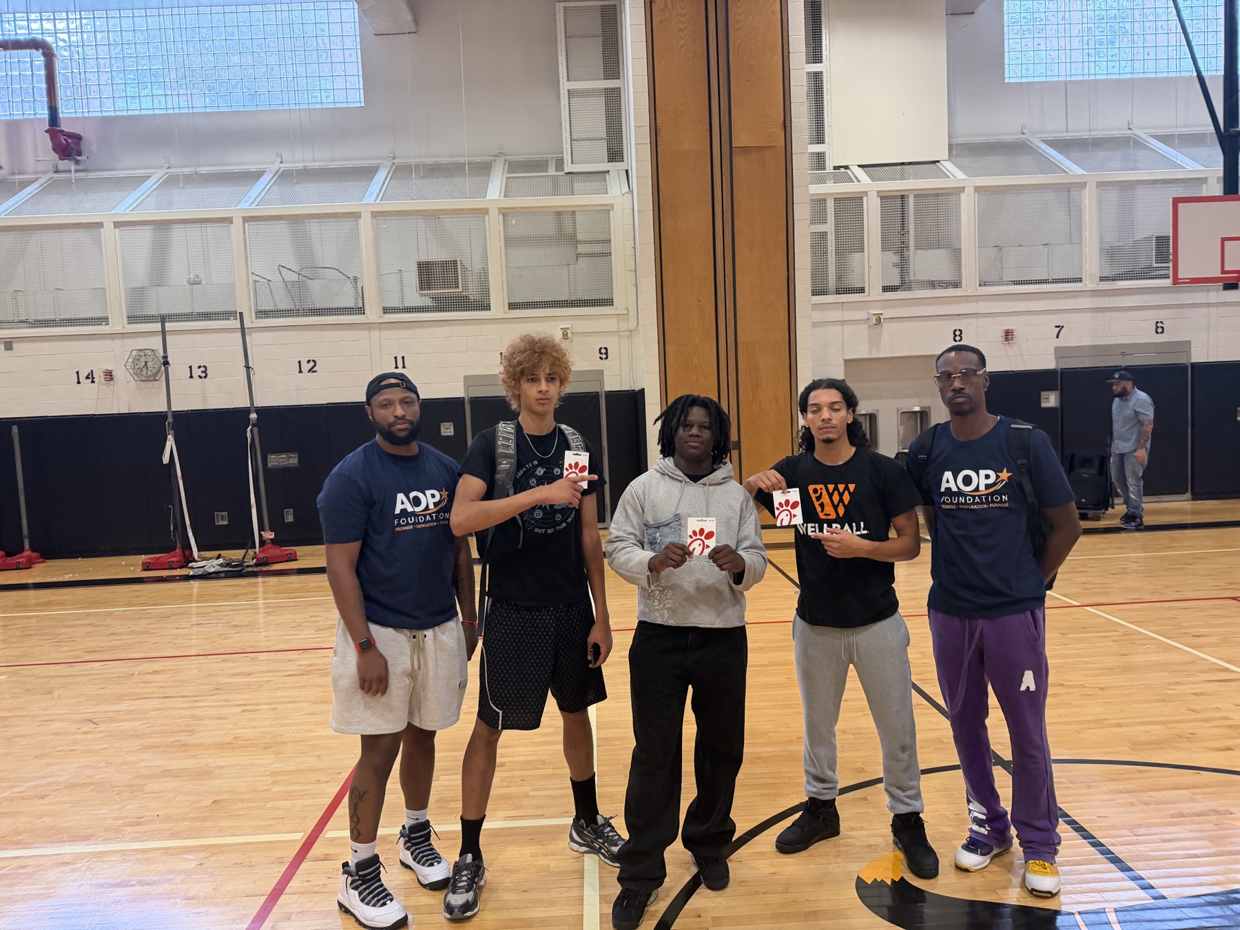 AOP coaches and students holding gift cards at the Back-to-School Community Kickoff.